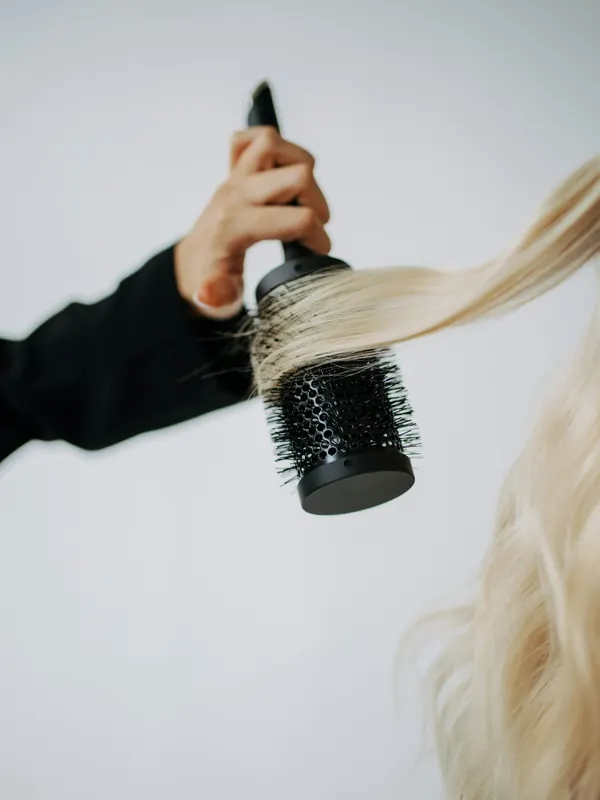 Blondes Haar wird mit einer Rundbürste gestylt