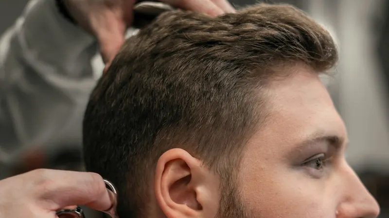 Barbier schneidet einem Mann den Bart mit der Schere